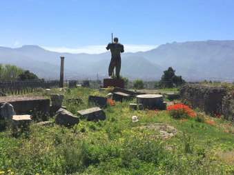 modern statue amidst ruins of Pompeii